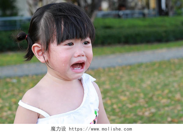 特写可爱的小女孩在公园里哭.